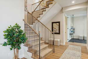 Stairway with wood finished floors and baseboards
