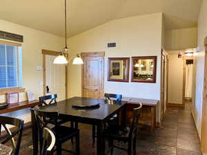 Dining space with baseboards and vaulted ceiling