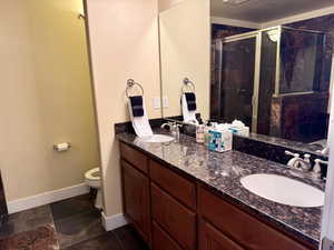 Bathroom featuring double vanity and a stall shower