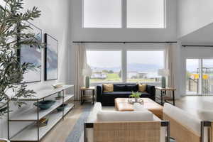 Living room featuring wood finished floors, healthy amount of natural light, a mountain view, and a high ceiling