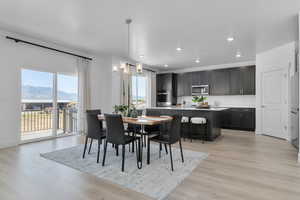 Dining area featuring light wood finished floors, recessed lighting, a chandelier, a mountain view, and a textured ceiling