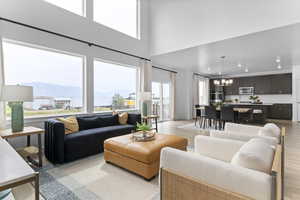 Living area with a chandelier, a mountain view, a high ceiling, light wood-style floors, and recessed lighting