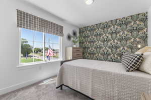 Bedroom featuring carpet flooring and an accent wall