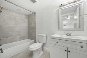 Full bath featuring washtub / shower combination, vanity, and a textured ceiling