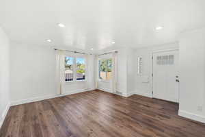 Foyer with dark wood-type flooring and recessed lighting