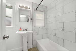 Full bath with shower / washtub combination and baseboards