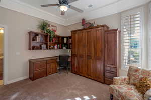 Office space with light carpet and a ceiling fan