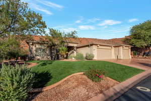 View of front of house with a garage, stucco siding, driveway, a front lawn, and a mountain view