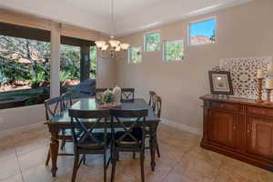 Dining area featuring light tile patterned floors and a chandelier