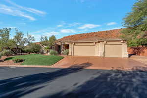 View of front facade with stucco siding, a front lawn, a garage, concrete driveway, and a mountain view