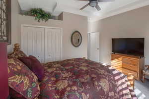 Bedroom featuring light carpet, ceiling fan, and a closet