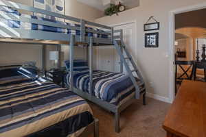 Bedroom featuring arched walkways and carpet floors