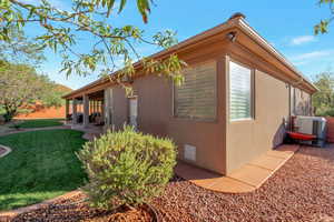 View of home's exterior with stucco siding and a yard