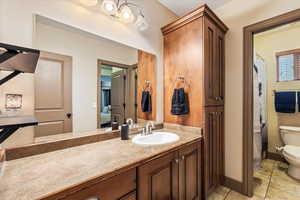 Bathroom with ensuite bathroom, vanity, light tile patterned floors, and curtained shower