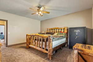 Carpeted bedroom featuring ceiling fan and baseboards