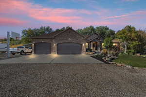 View of front facade featuring concrete driveway, a garage, brick siding, and a front yard