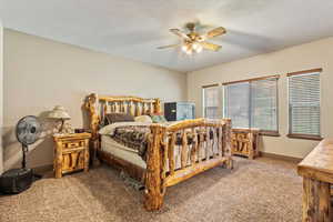 Carpeted bedroom featuring a ceiling fan and baseboards