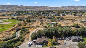 Aerial view of property and surrounding area featuring a mountain backdrop and nearby suburban area