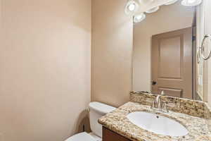 Half bathroom featuring a textured wall and vanity