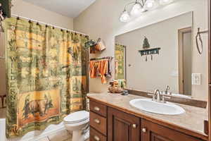 Bathroom with light tile patterned flooring, shower / bath combo, and vanity