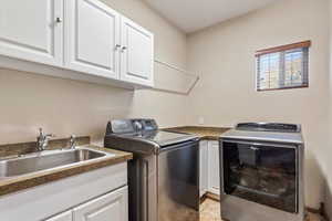 Washroom featuring cabinet space, independent washer and dryer, and light tile patterned floors