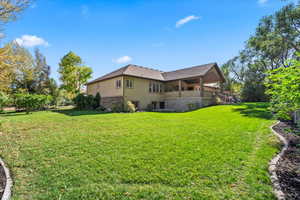 Back of property featuring stucco siding, a lawn, and stairway