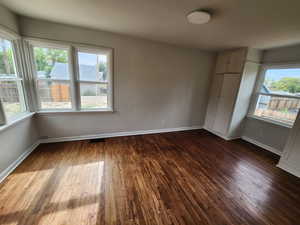 Unfurnished bedroom featuring dark wood-type flooring and a closet