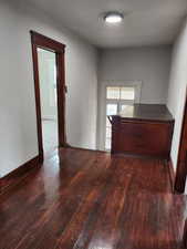 Foyer featuring dark wood-type flooring and baseboards
