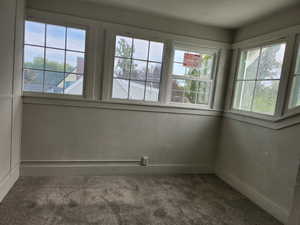 Spare room featuring dark carpet and a textured wall