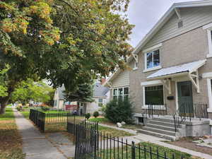 View of front of home with brick siding and a fenced front yard