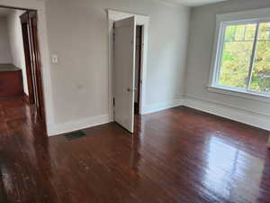 Unfurnished room with dark wood finished floors and baseboards