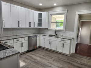 Kitchen with white cabinetry, light stone counters, a textured ceiling, and recessed lighting