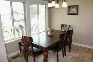 Dining room with plenty of natural light, a chandelier, and stone tile flooring