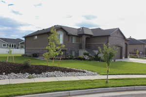 View of front of property featuring brick siding, a garage, and concrete driveway