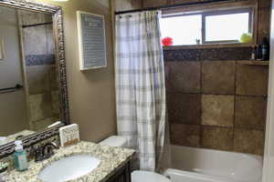 Full bathroom featuring shower / tub combo with curtain and vanity