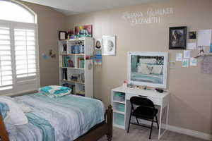 Bedroom featuring carpet and baseboards