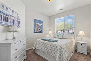 Bedroom with dark carpet and baseboards
