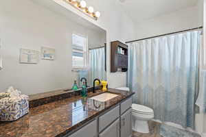 Full bath with vanity, shower / tub combo with curtain, and light wood-style floors