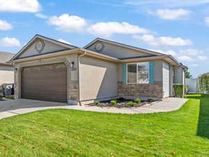 Single story home with concrete driveway, stucco siding, and an attached garage