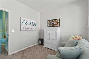 Sitting room featuring carpet and baseboards