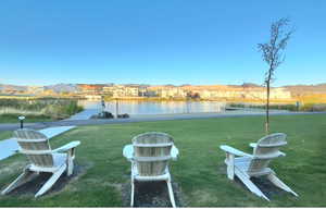 View of grassy yard featuring a water and mountain view and a residential view