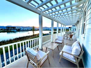 Patio terrace at dusk featuring an outdoor living space, a pergola, a water and mountain view, and a patio
