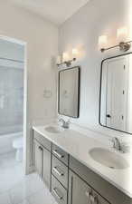 Full bathroom featuring double vanity and washtub / shower combination