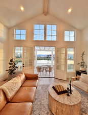 Living area featuring hardwood / wood-style flooring, a water view, recessed lighting, high vaulted ceiling, and healthy amount of natural light