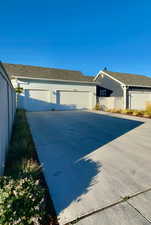 View of side of home featuring concrete driveway and an attached garage