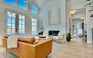 Living room featuring a high ceiling and light wood finished floors