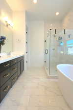 Bathroom with a soaking tub, light marble finish flooring, vanity, a marble finish shower, and recessed lighting