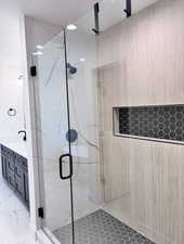 Full bathroom with a marble finish shower and double vanity