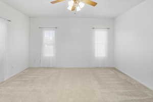 Room with light carpet and a ceiling fan
