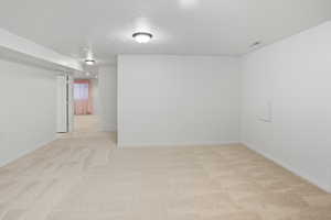 Spare room with light carpet and baseboards